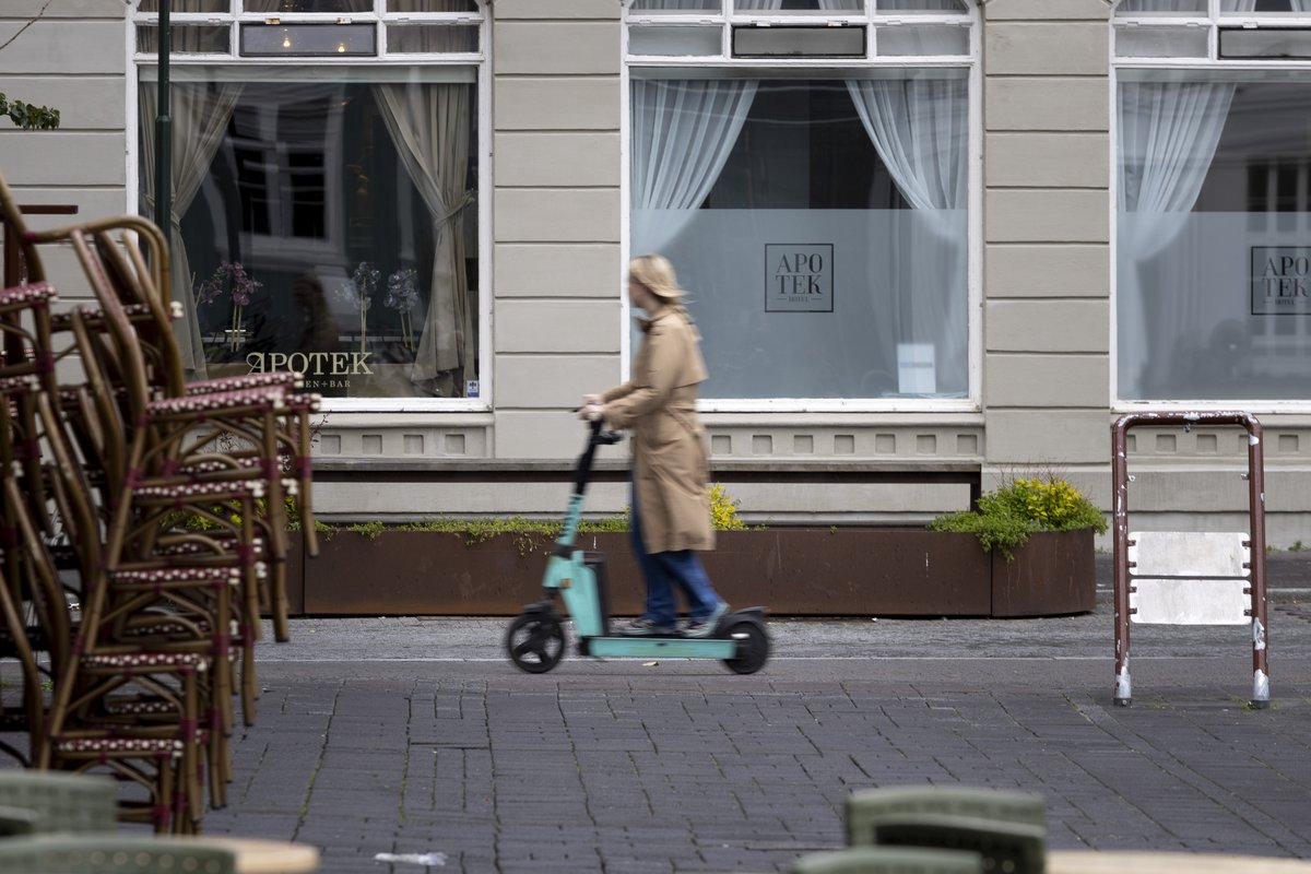 Kona fer frá Austurvelli á rafskútu